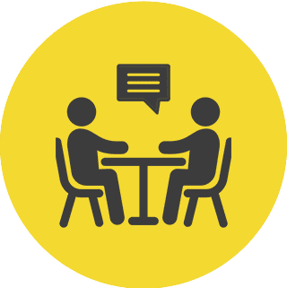 Two people talking at a table icon.