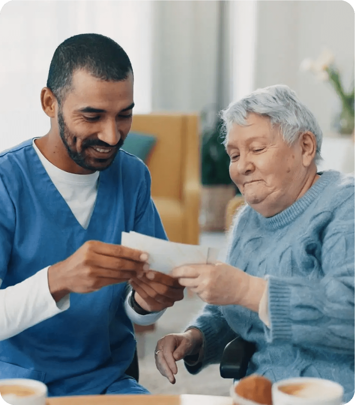 Caregiver and elderly woman looking at photo.