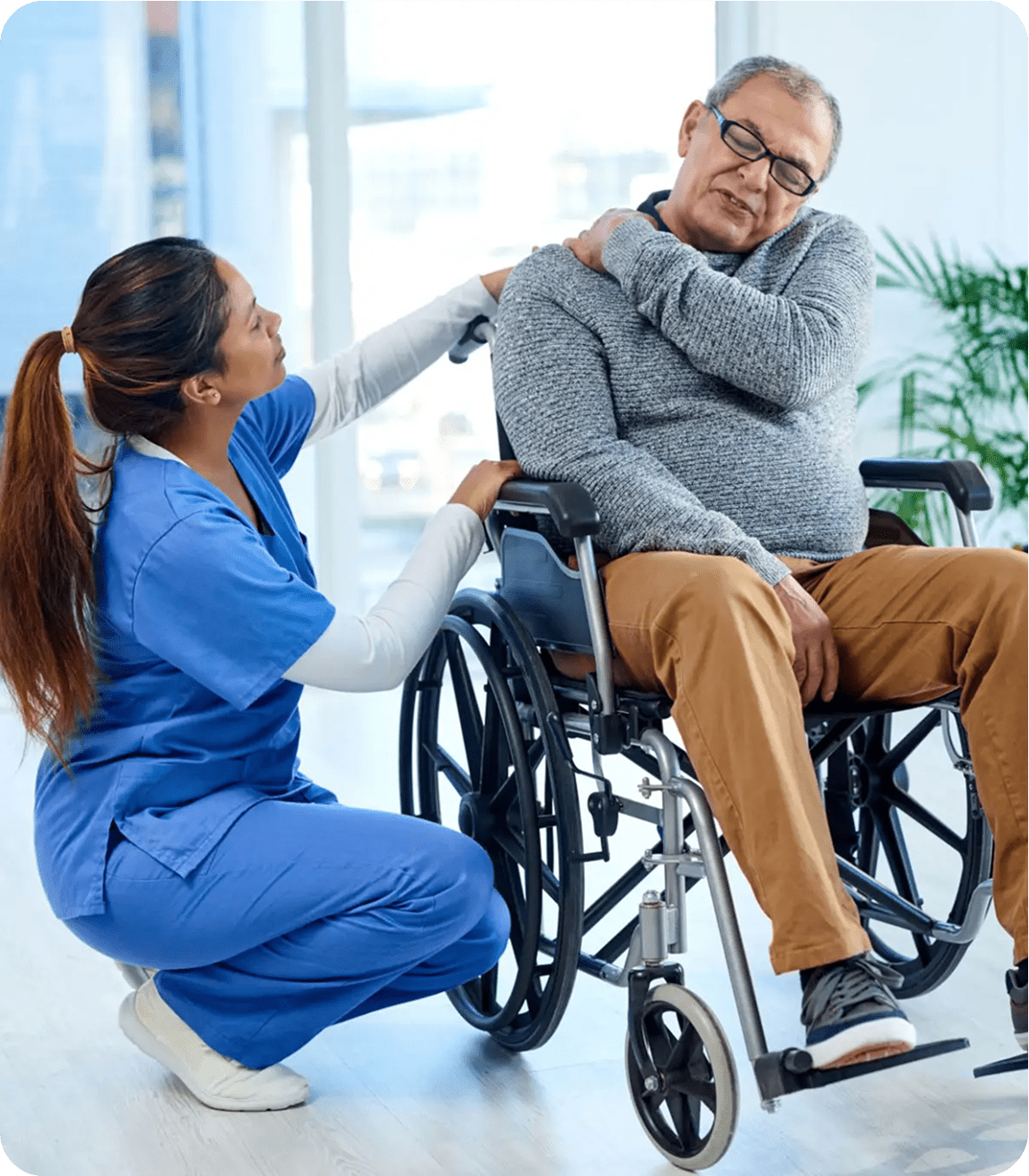 Nurse assisting man in wheelchair with shoulder.